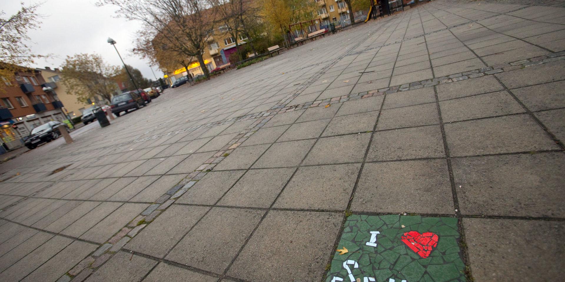 En färggrann kakelplatta med texten 'I love Seved' bryter av mot de grå markplattorna i bostadsområdet Seved (Södra Sofielund) i Malmö. Arkivbild.