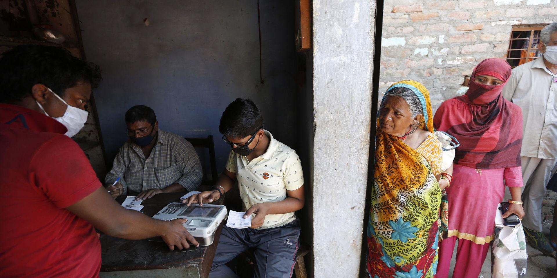 Fattiga indier i staden Prayagraj lämnar fingeravtryck för att hämta ut livsmedelsransoner på torsdagen. Indien är ett av flera länder som Världsbanken ska rikta ytterligare stöd till i virustider.