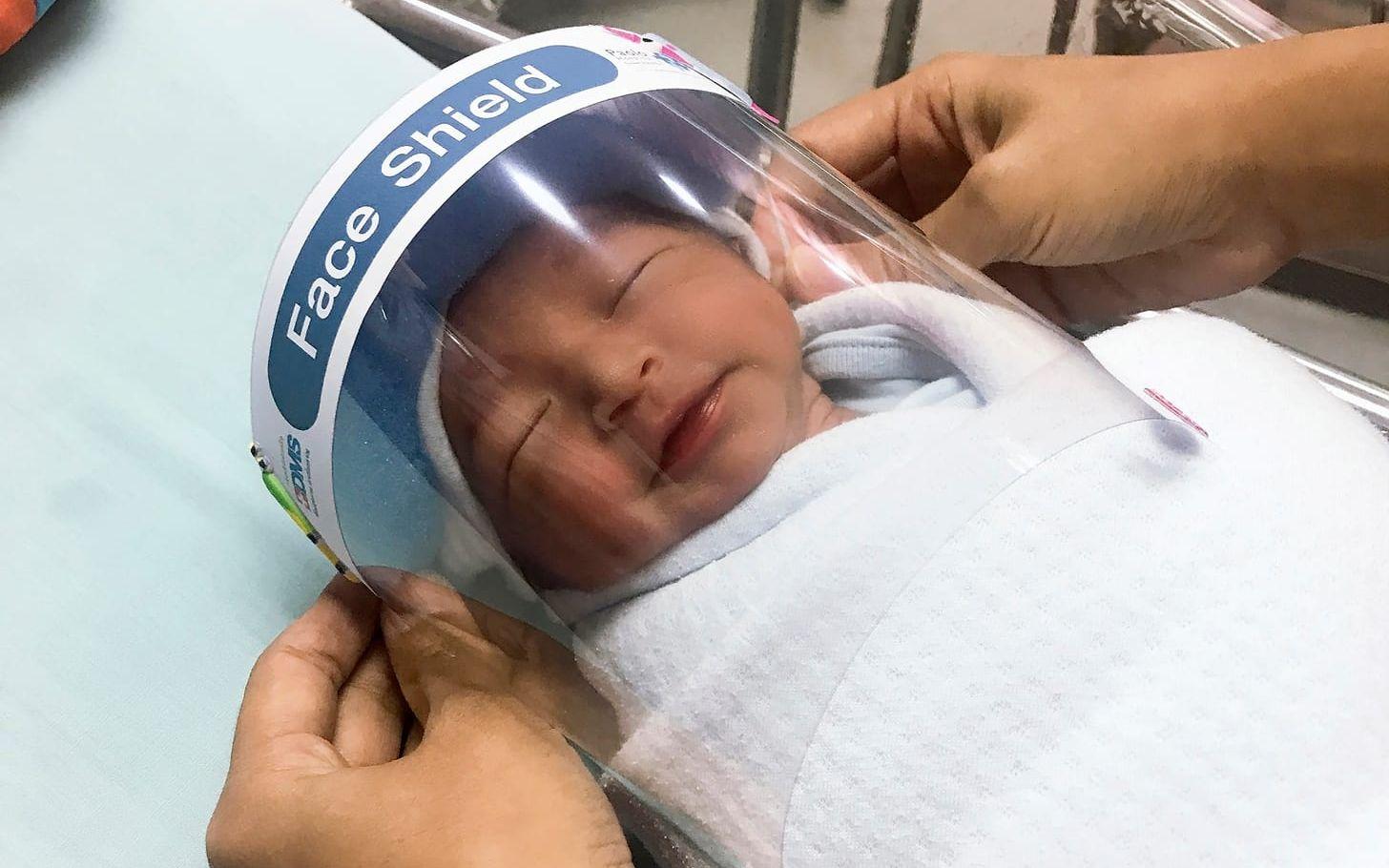 En sköterska rättar till ett skyddsvisir på en bebis på Paolosjukhuset. 