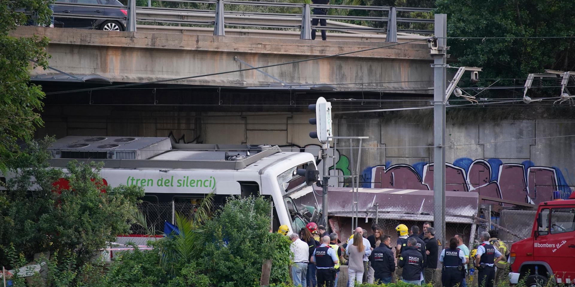 Polis och räddningsarbetare på den plats utanför Barcelona där ett godståg kolliderade med ett passagerartåg på måndagskvällen.