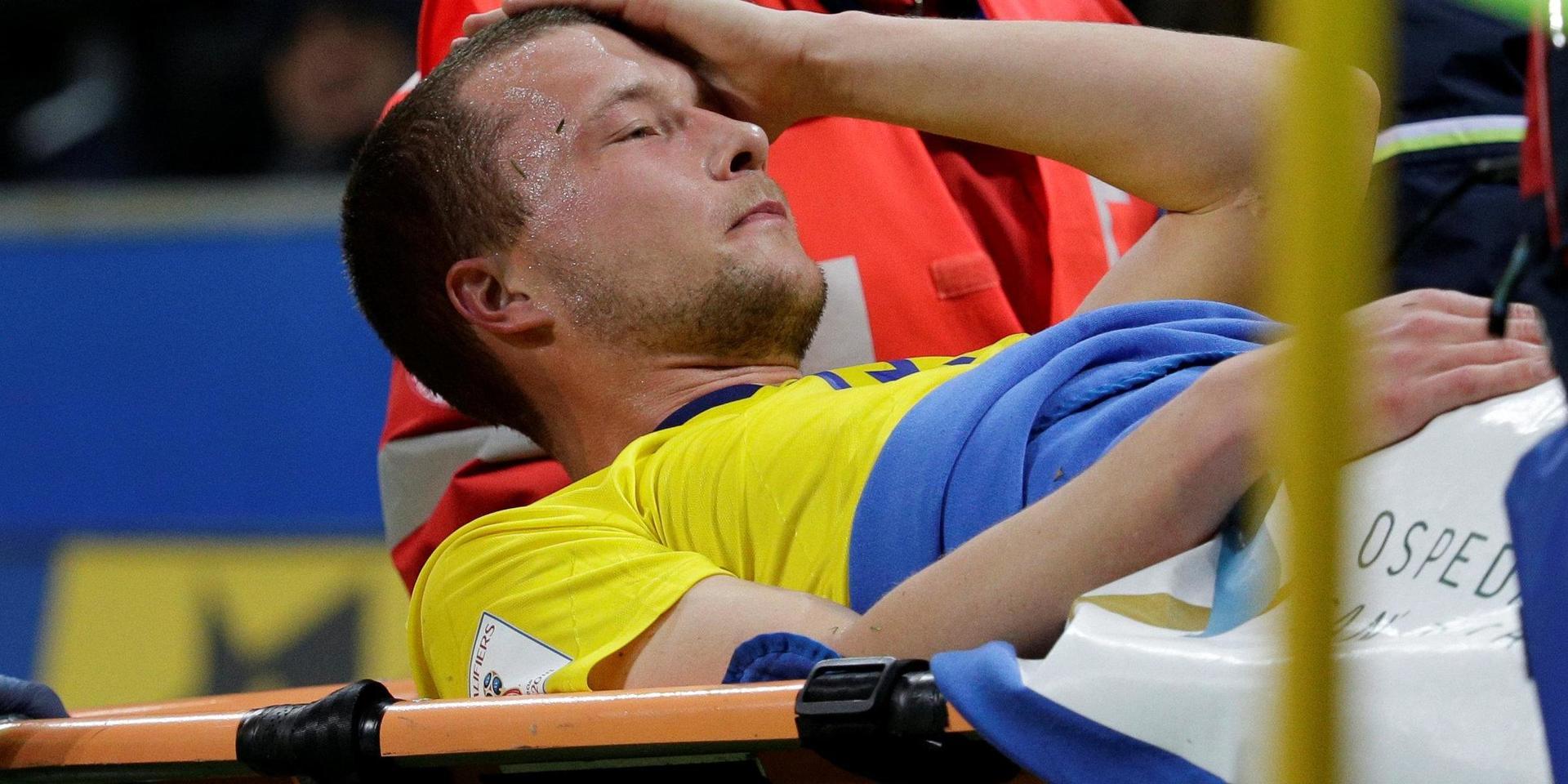 Jakob Johansson blir utburen på bår efter att ha vridit till vänster knä i VM-playoffet mot Italien i november 2017.