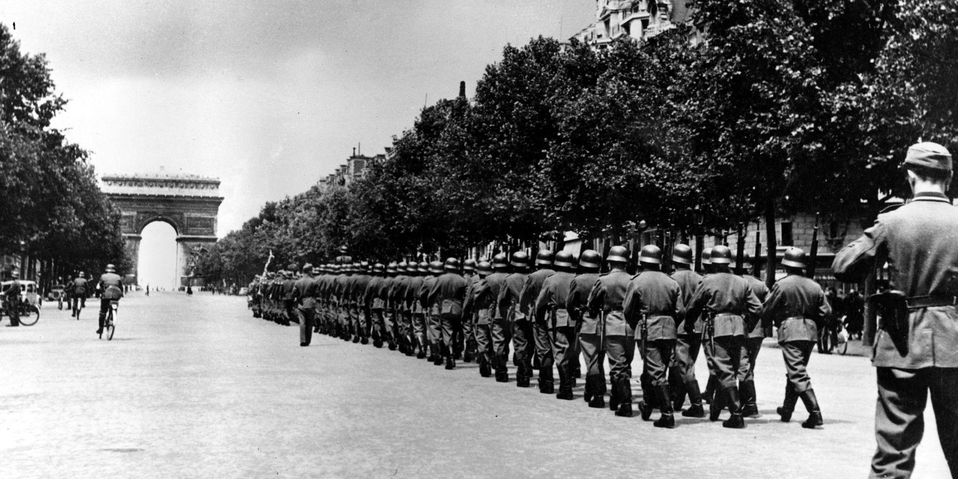 En fransk man vars far tvingades strida för Nazityskland kräver tysk ersättning för sin föräldralöshet. På bilden marscherar tyska soldater på Champs-Élysées, Paris, i september 1944. Arkivbild.