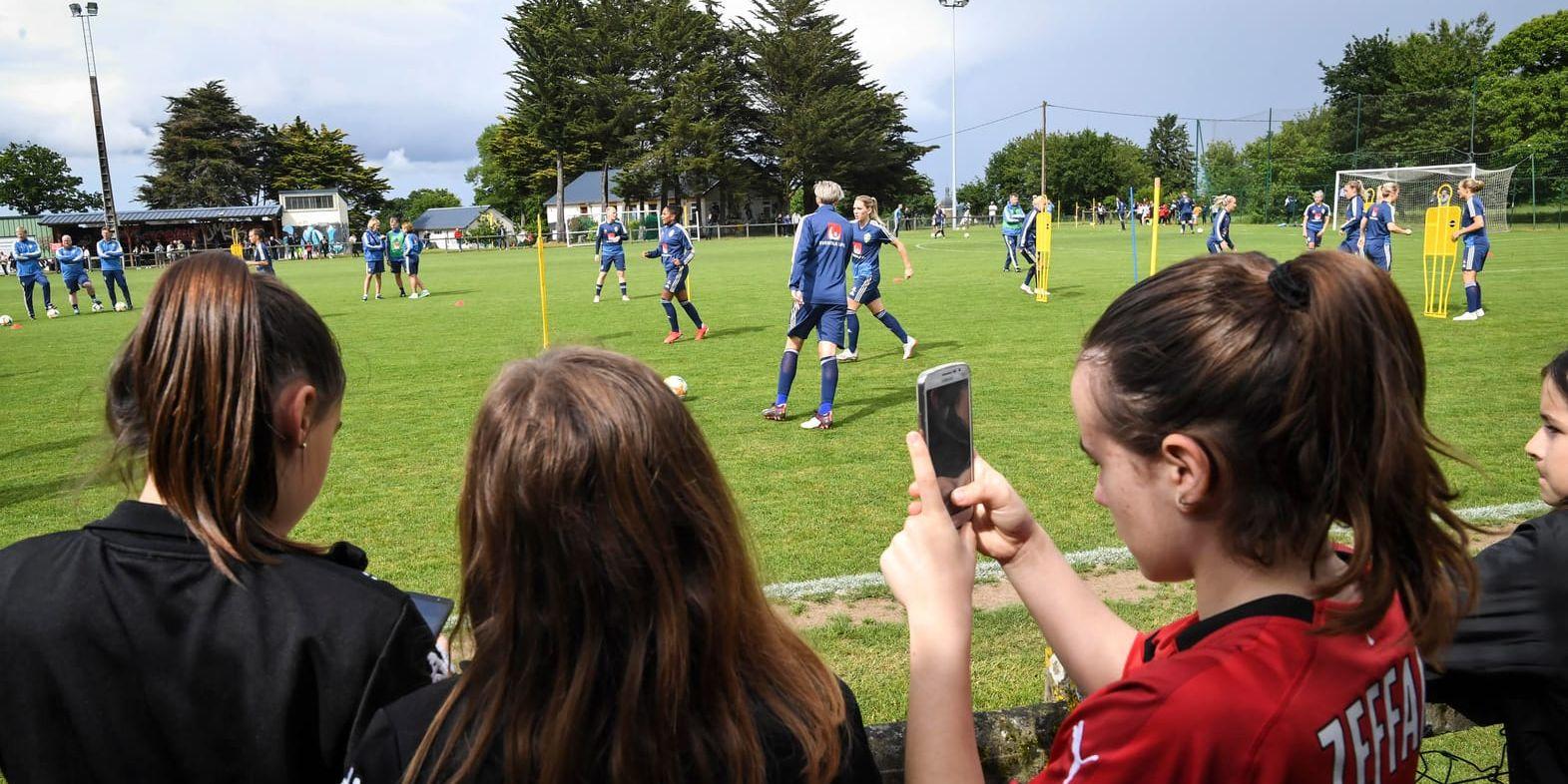 Unga supportrar ser på när landslaget gör sitt första träningspass i Frankrike.
