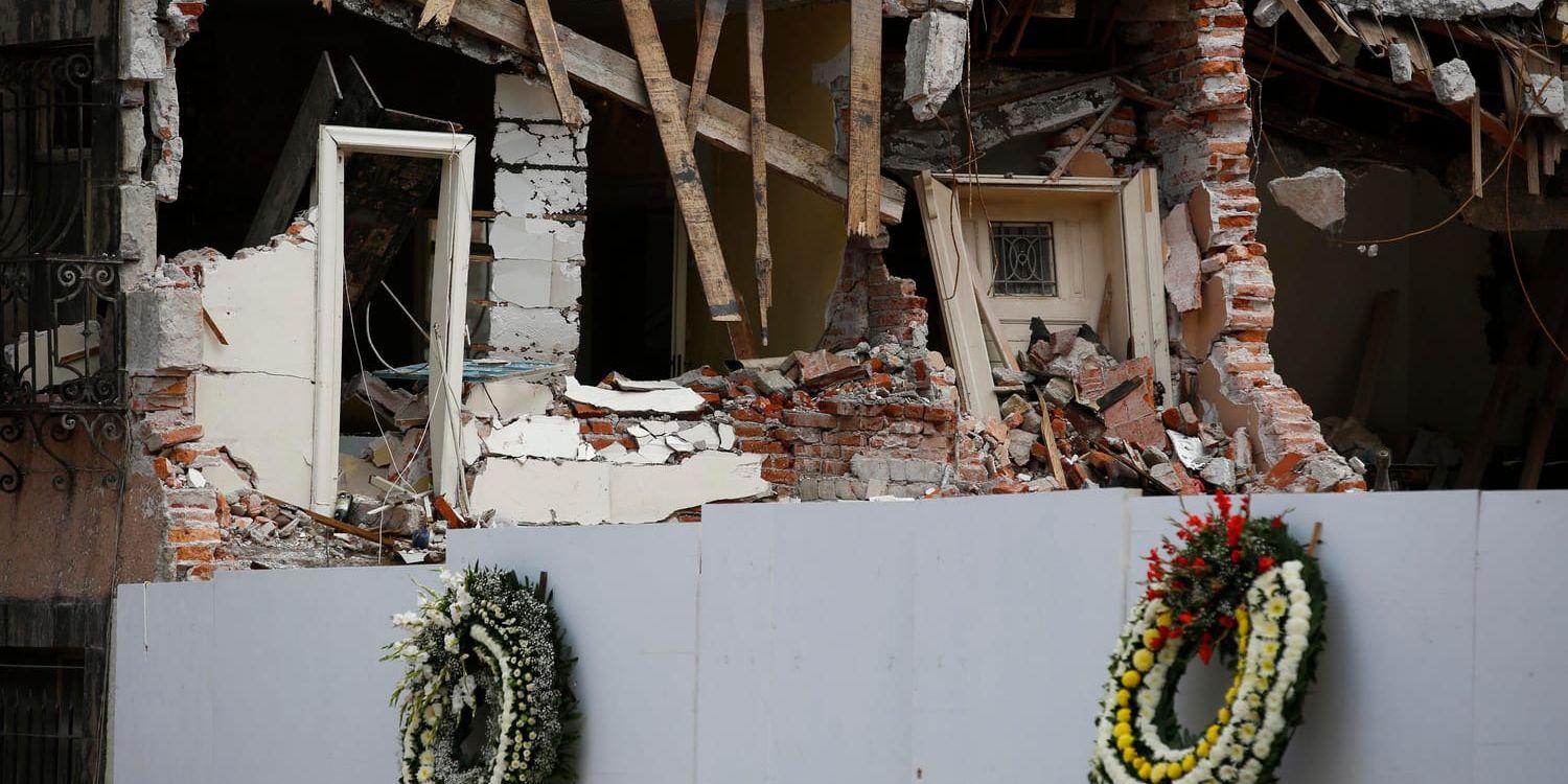 Blomkransar hänger vid en kollapsad kontorsbyggnad i stadsdelen Roma i Mexico City, som drabbades hårt av skalvet.