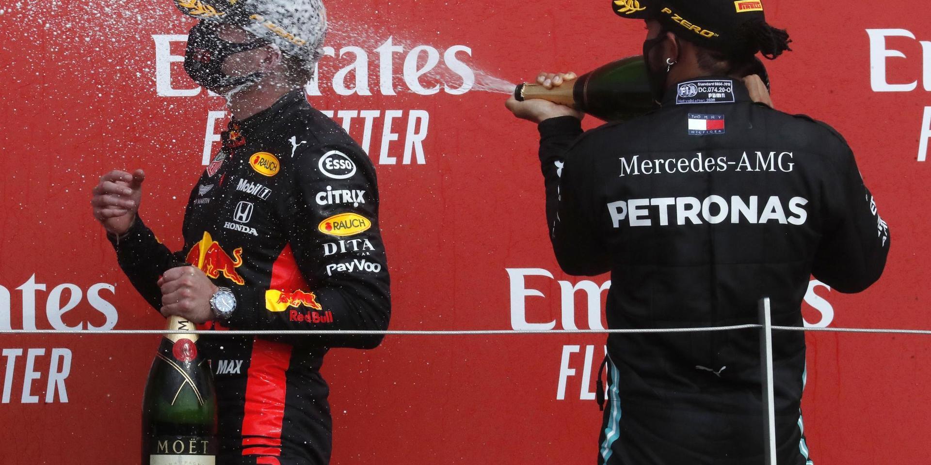 Red Bulls Max Verstappen, vänster, sprutades ned med champagne av Mercedes regerande världsmästare Lewis Hamilton efter F1-segern på Silverstone.