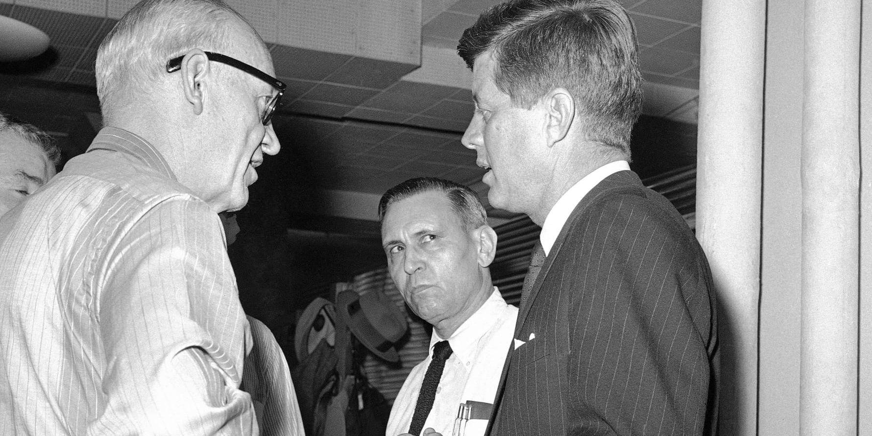 Den demokratiske USA-presidenten John F Kennedy (till höger i bild), här i samspråk med nyhetsbyrån AP:s reportrar Relman "Pat" Morin och Douglas Cornell, mördades under ett besök i Dallas i Texas 1963.