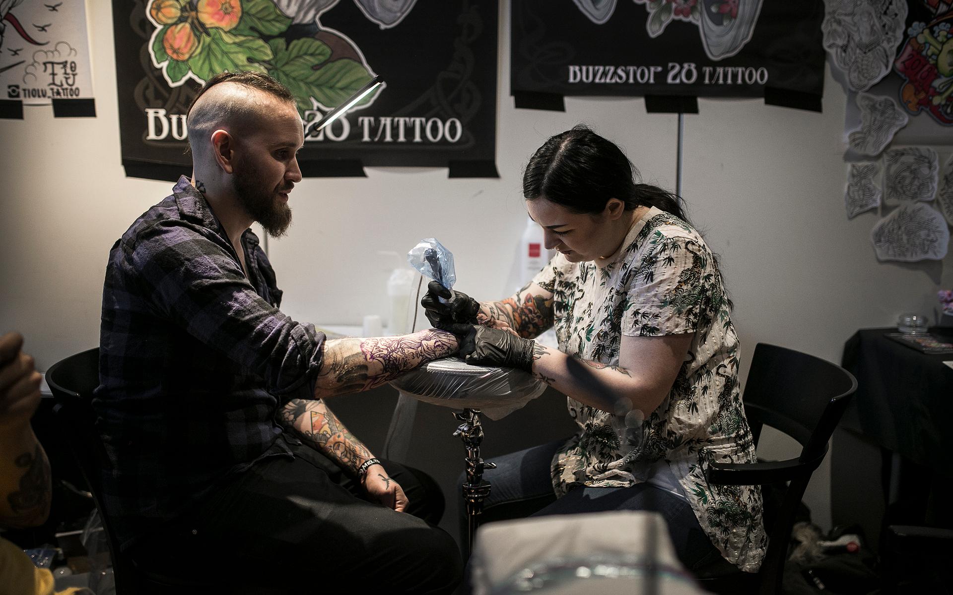 Sanna Artelius gör en tatuering på Petter Jonssons arm.