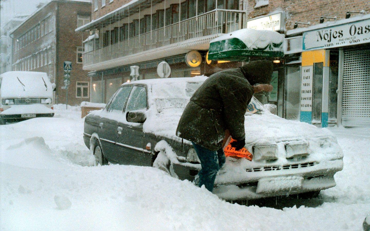 Snökaos 17 november 1995. En person borstar av snön på bilen i Trollhättan. 