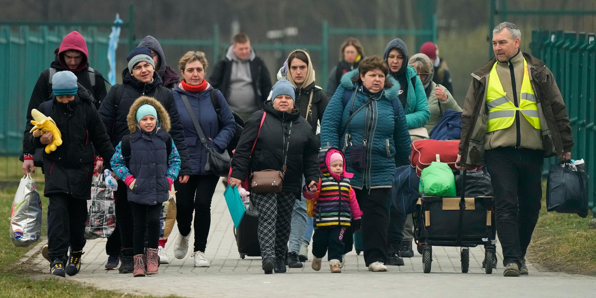 Refugees walk after fleeing the war from neighbouring Ukraine at the border crossing in Medyka, southeastern Poland, Saturday, April 2, 2022. (AP Photo/Sergei Grits)  XB162