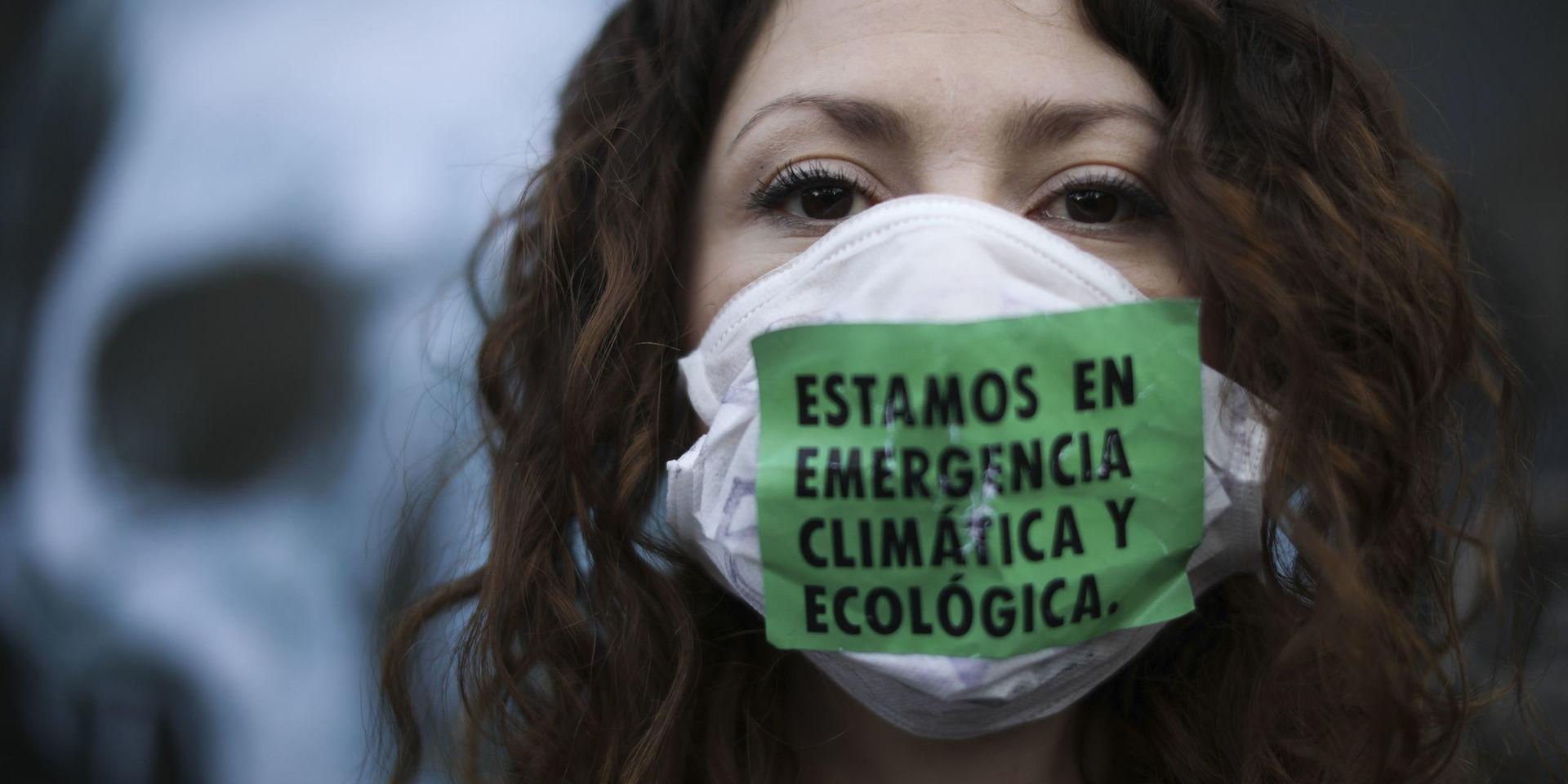 'Vi är i ett nödläge för klimatet och ekologin' står det på ansiktsmasken som en demonstrant bär vid demonstrationer utanför Brasiliens ambassad i Argentinas huvudstad Buenos Aires i augusti i år. Demonstranterna uppmanade specifikt Brasiliens president Jair Bolsonaro att skydda regnskogen i Amazonas.