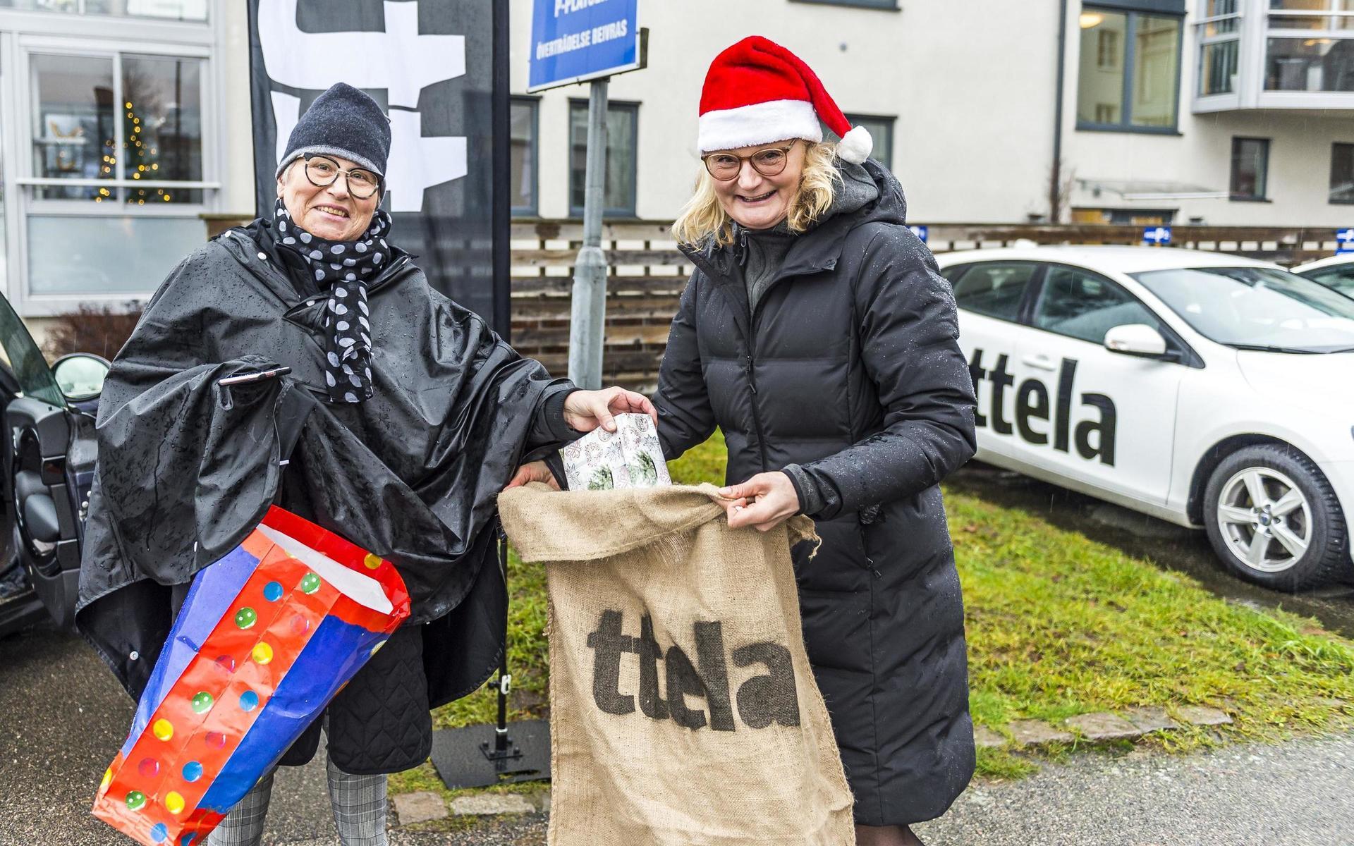 Eva Hedeberg lämnar över julklappar till TTELA:s chefredaktör Cecilia Frisk under julklappsinsamlingen i Vänersborg.