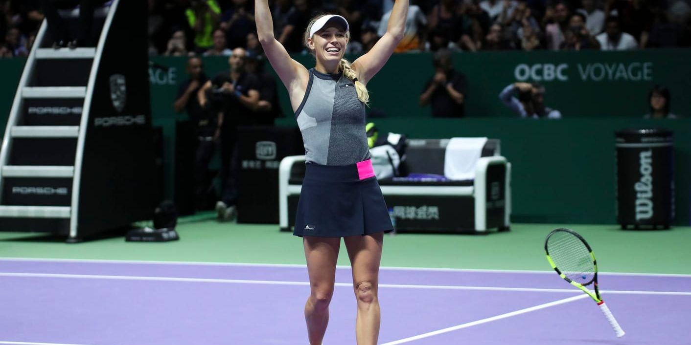 Caroline Wozniacki kastar sin racket efter att ha slagit in matchbollen mot Venus Williams i WTA-slutspelet i tennis.