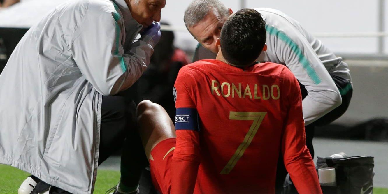 Portugals Cristiano Ronaldo får behandling efter sin skada i EM-kvalet mot Serbien.