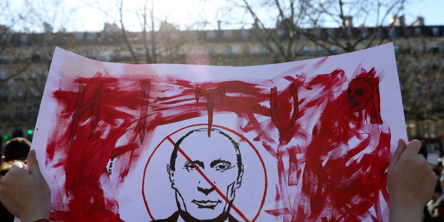 En Putinkritisk demonstrant håller upp en banderoll under en protest mot kriget i Ukraina i Paris i februari 2022.
