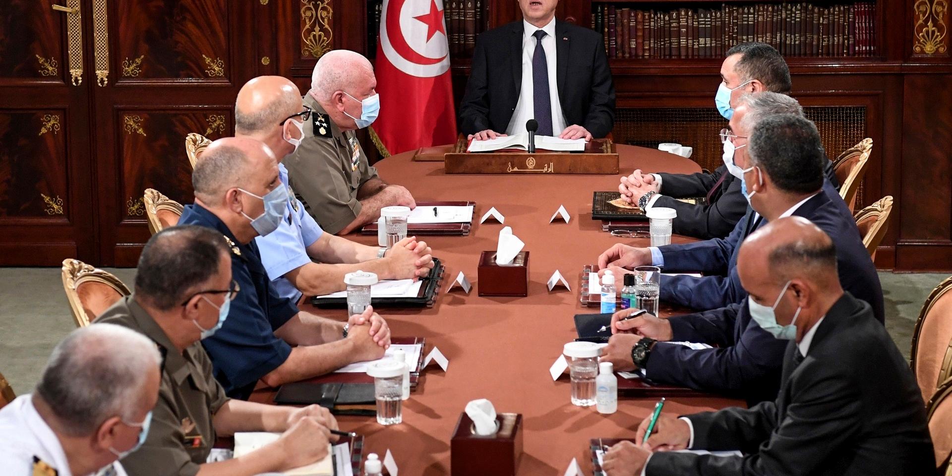 Tunisiens president Kaïs Saied, i mitten, leder ett möte med polis och militär på måndagen, dagen efter att han petat premiärministern.