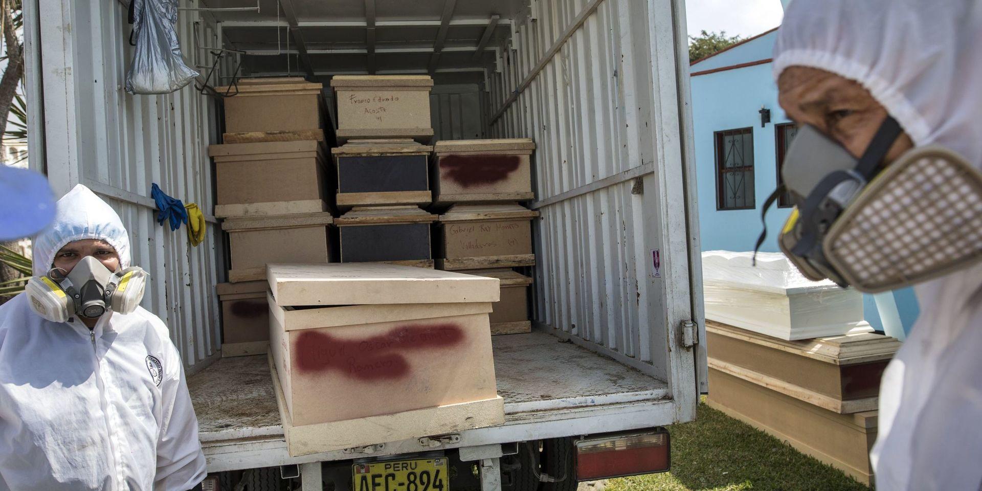 Begravningsarbetare lastar ur kistor med kvarlevorna av personer som misstänks ha avlidit i sviterna av det nya coronaviruset i Perus huvudstad Lima. 