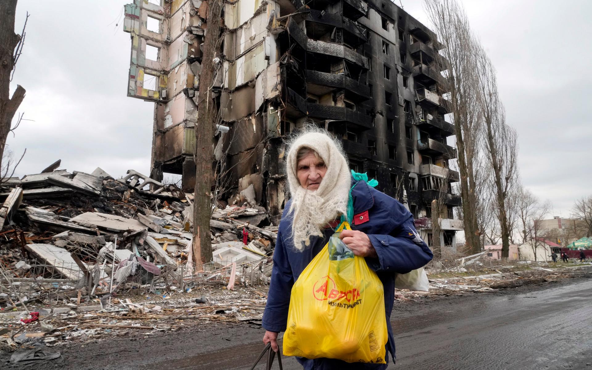 An elderly woman walks by an apartment building destroyed in the Russian shelling in Borodyanka, Ukraine, Wednesday, April 6, 2022. (AP Photo/Efrem Lukatsky)  NYAG504